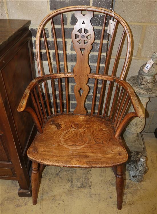 An early 19th century elm and ash wheel back elbow chair